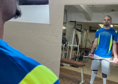 Muž v modro-žltom športovom drese v interiéri (posilňovňa).